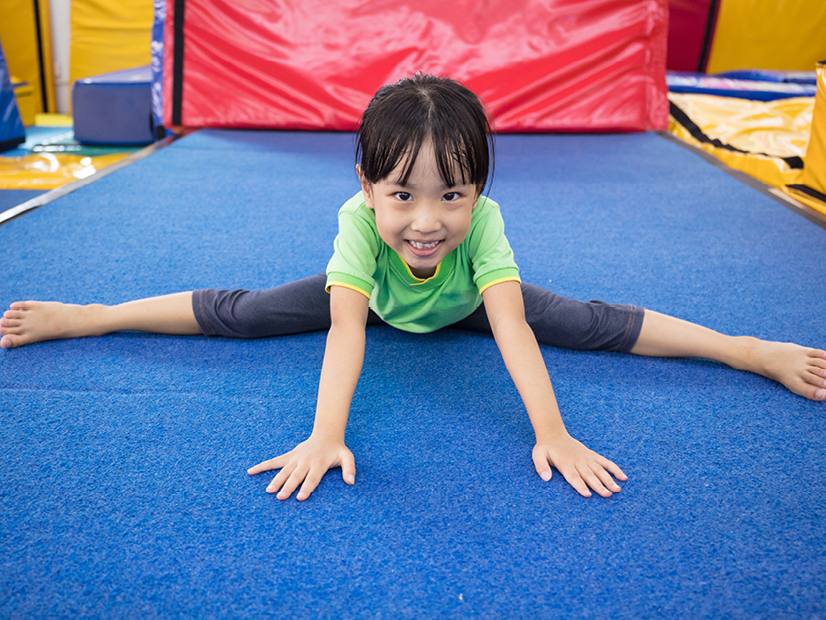 A child is stretching during a gymnastics lesson.